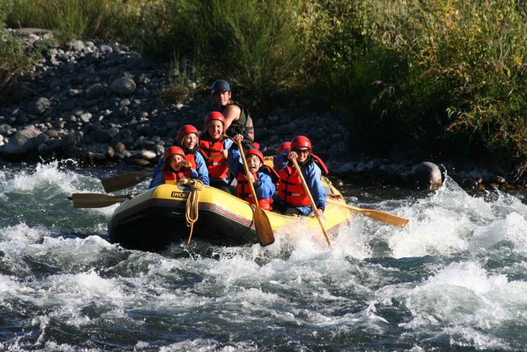 A group in a raft tackling white water rapids on a Class 3 River.