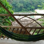 A hammock with a view of the Amazon jungle and river behind.